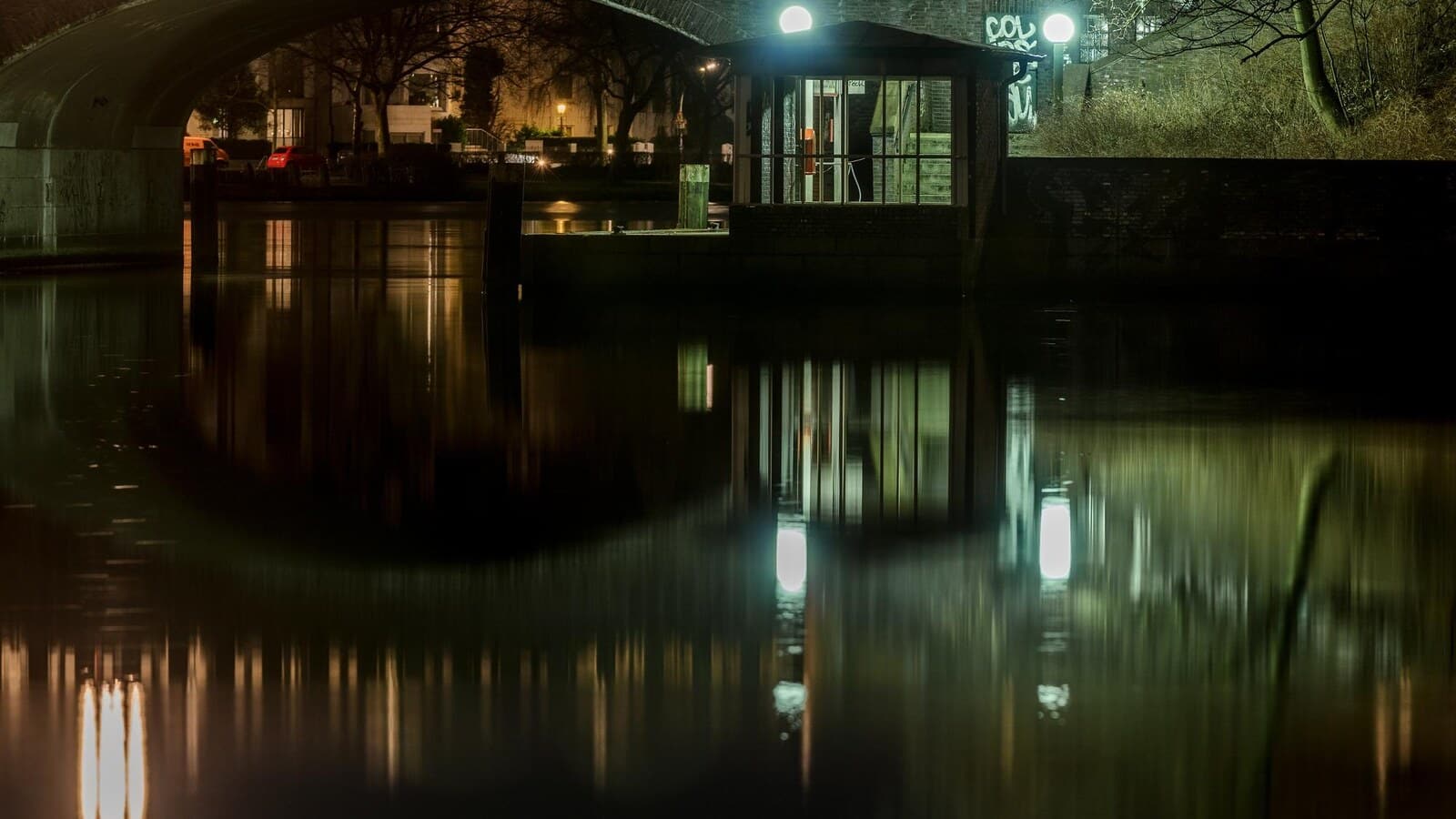 Horizontal cinematic image of a haunted historic hotel exterior at night